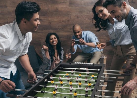 gente de un club jugando al futbolin